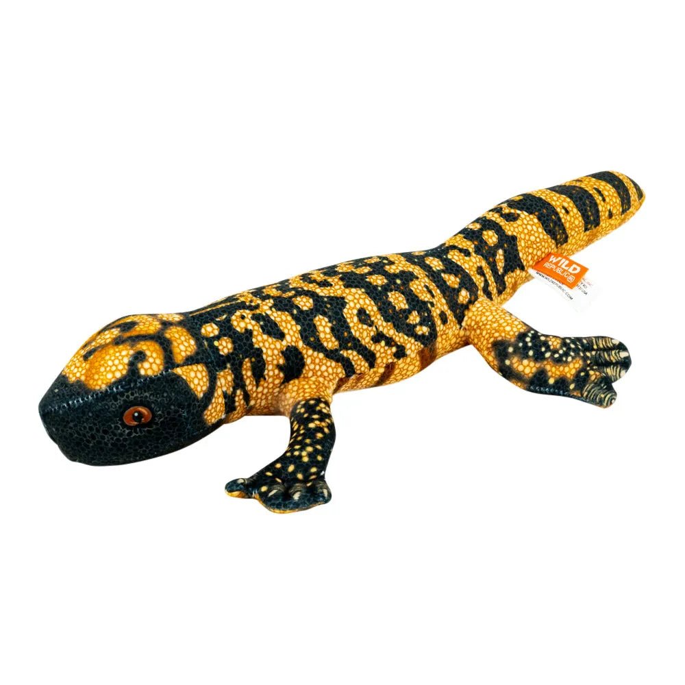 A realistic plush toy gila monster with a black body covered in bright yellow-orange spotted patterns, a black head, and a small orange tag attached near the tail, shown on a plain white background.
