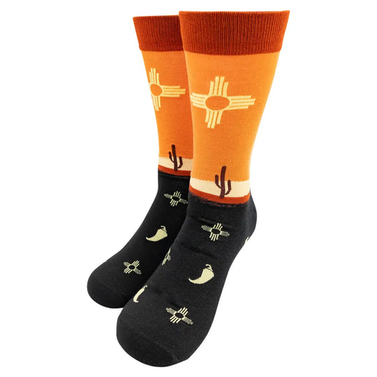 Orange knit sock with desert design and a Zia Sun against a white background