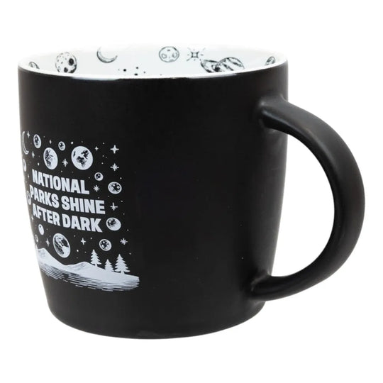 Black mug with white nature graphics and text on a white background