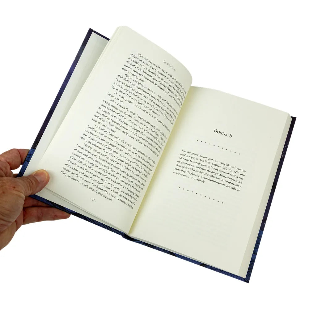 An open book with printed text pages held open by a person&