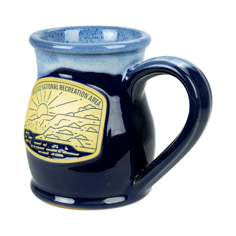 A ceramic mug with a dark blue body, a lighter blue speckled interior, and a yellow National Recreation Area emblem on the side, shown against a plain white background.