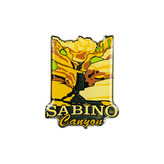 A Sabino Canyon photo dome pin featuring a stylized canyon landscape with yellow and orange rock formations, green trees, and the text &