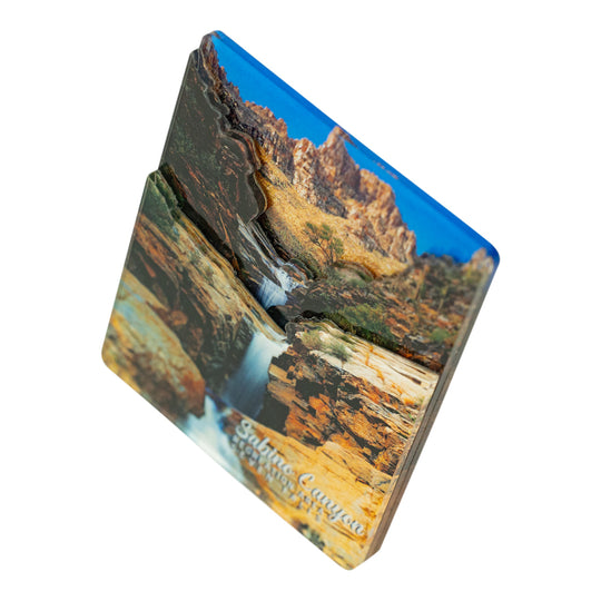 An acrylic featuring a 3D raised design of a canyon landscape with a waterfall, labeled &