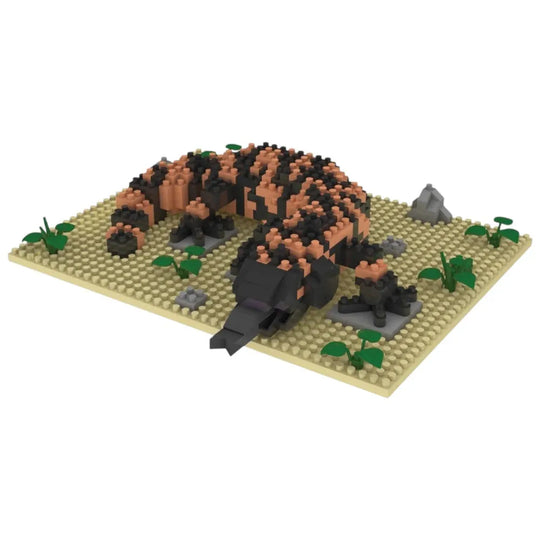Toy model of a gila monster on a beige base with green plants and gray rocks