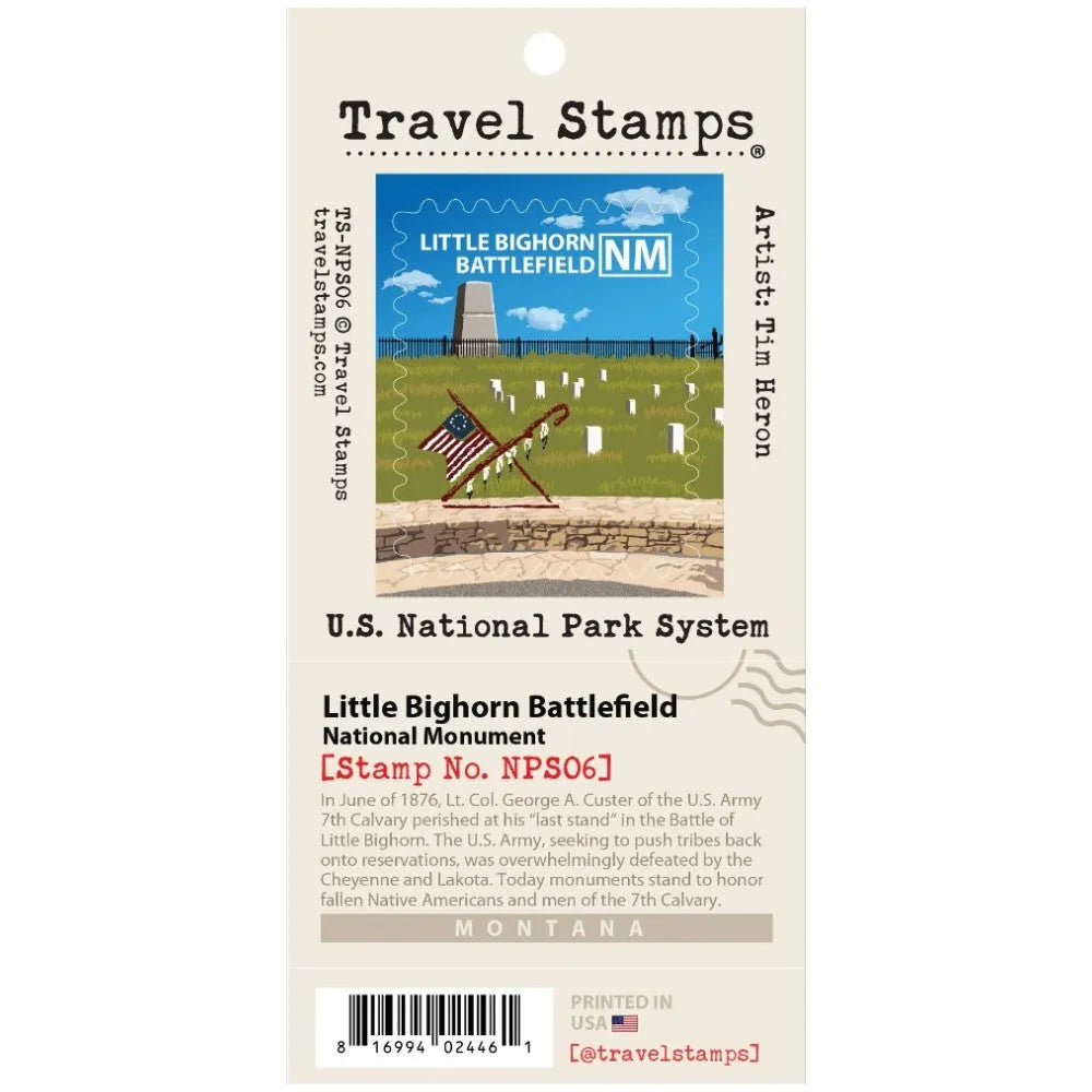 A retail package of Travel Stamps featuring the Little Bighorn Battlefield National Monument stamp design. The packaging is cream-colored with black text and shows the illustrated stamp design with a blue sky, white flag, and green field.