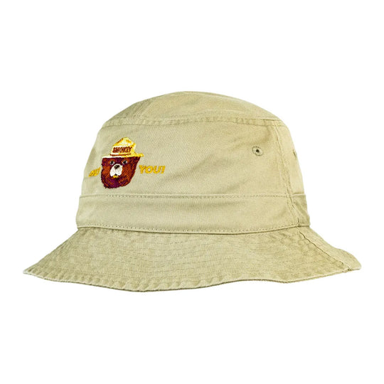 A light khaki bucket hat with a small embroidered logo on the front featuring Smokey Bear.