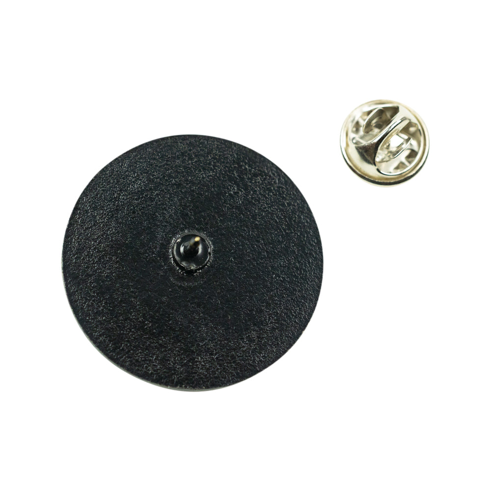 A round black textured fabric pin-back button shown from the back, alongside its metal clutch backing on a plain white background.