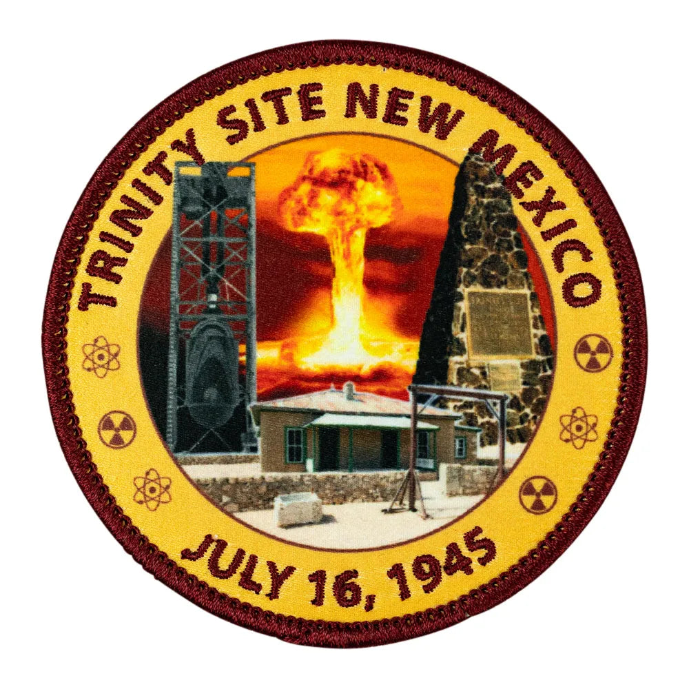 A circular embroidered patch depicting the Trinity Site in New Mexico, featuring a nuclear explosion mushroom cloud, radiation symbols, and the text &