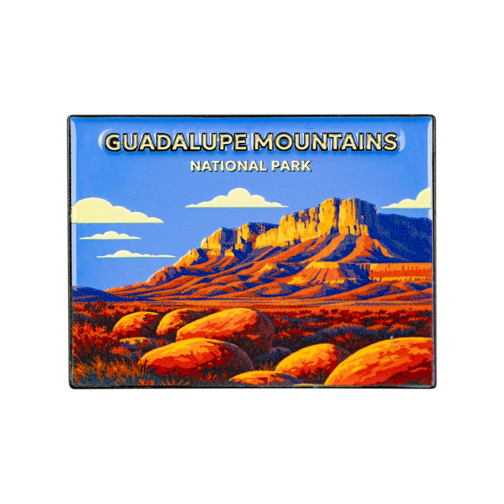 A rectangular souvenir pin featuring a colorful illustration of Guadalupe Mountains National Park, with the text &