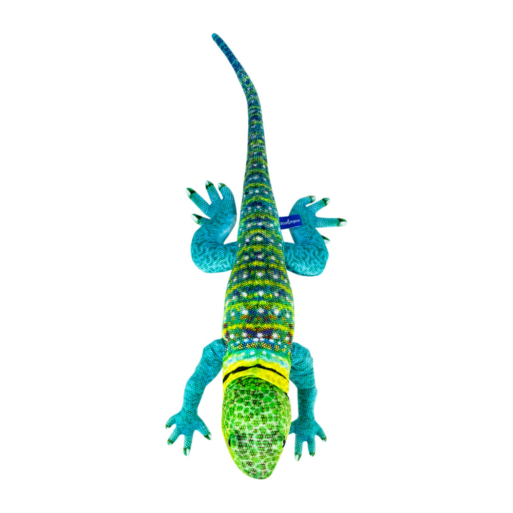 A colorful lizard plush toy shown from above on a plain white background. The body is primarily green and blue with bright turquoise legs and hands, a yellow band around the neck, and multicolored scale details along the back.