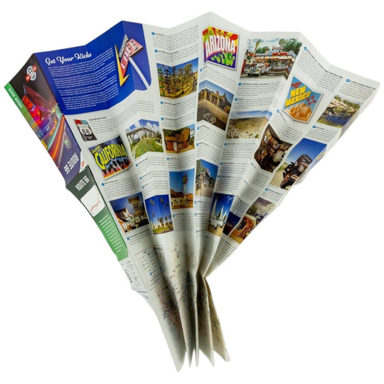 A folded paper map opened to show multiple printed pages with colorful travel imagery and text, photographed on a plain white background.
