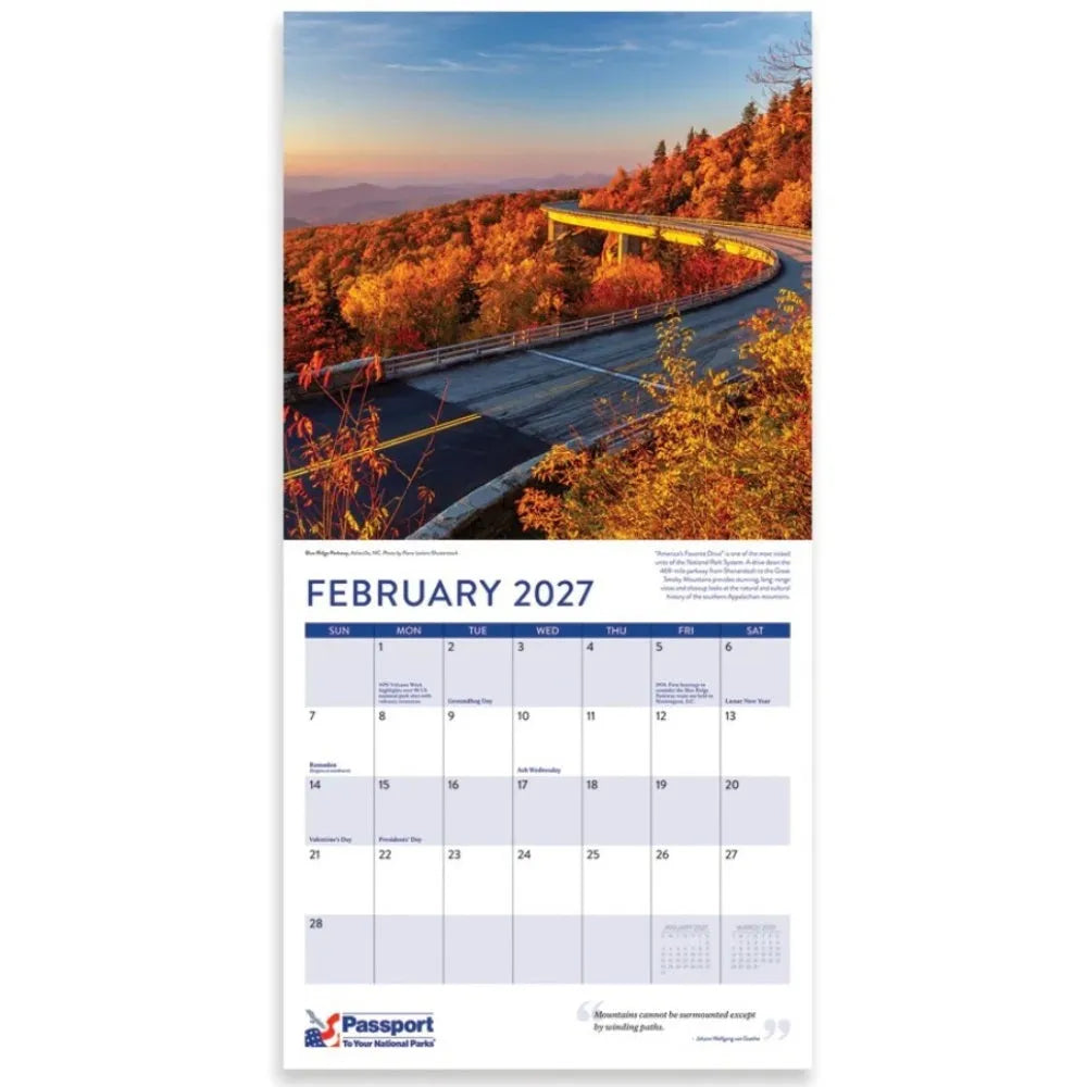 Passport 2027 wall calendar page showing a scenic autumn mountain road photograph on the top half and a February 2027 calendar grid on the bottom half, with the Passport logo at the bottom.
