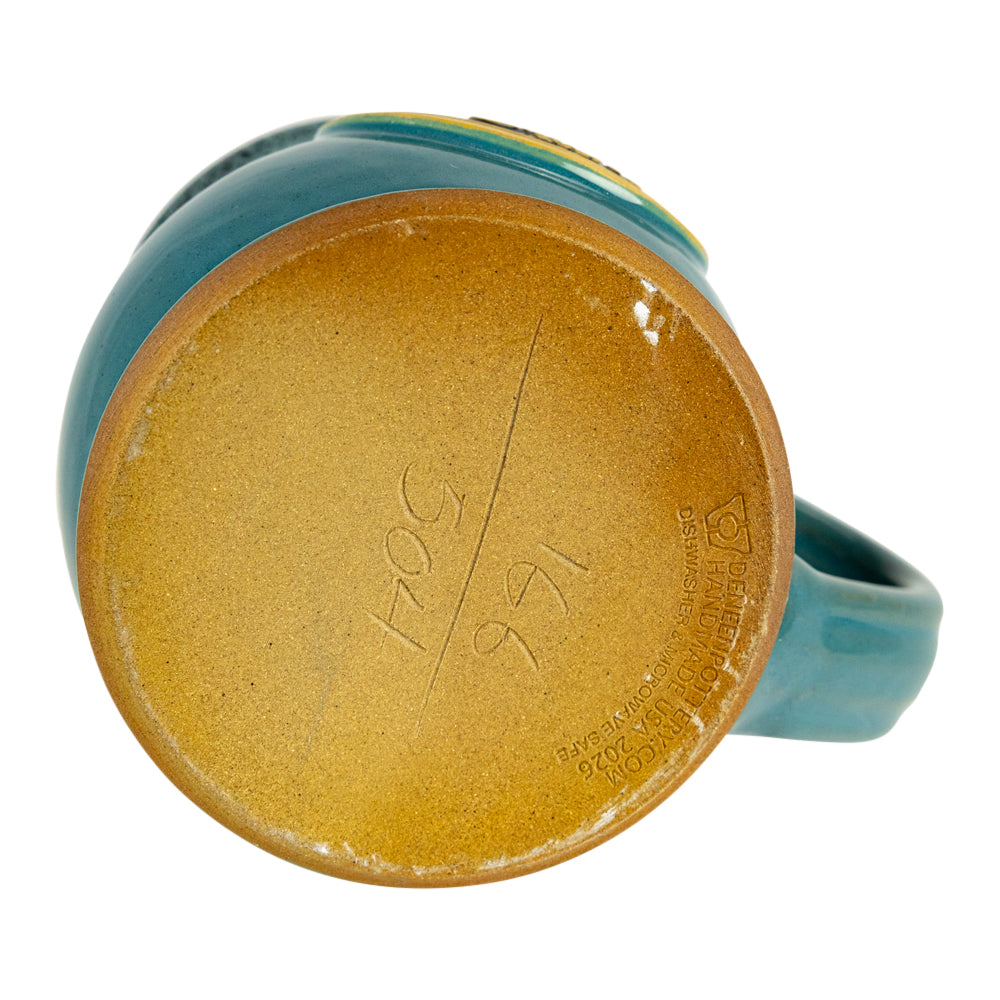 Close-up of the bottom of a ceramic mug showing a glossy gold-toned interior base with embossed maker&