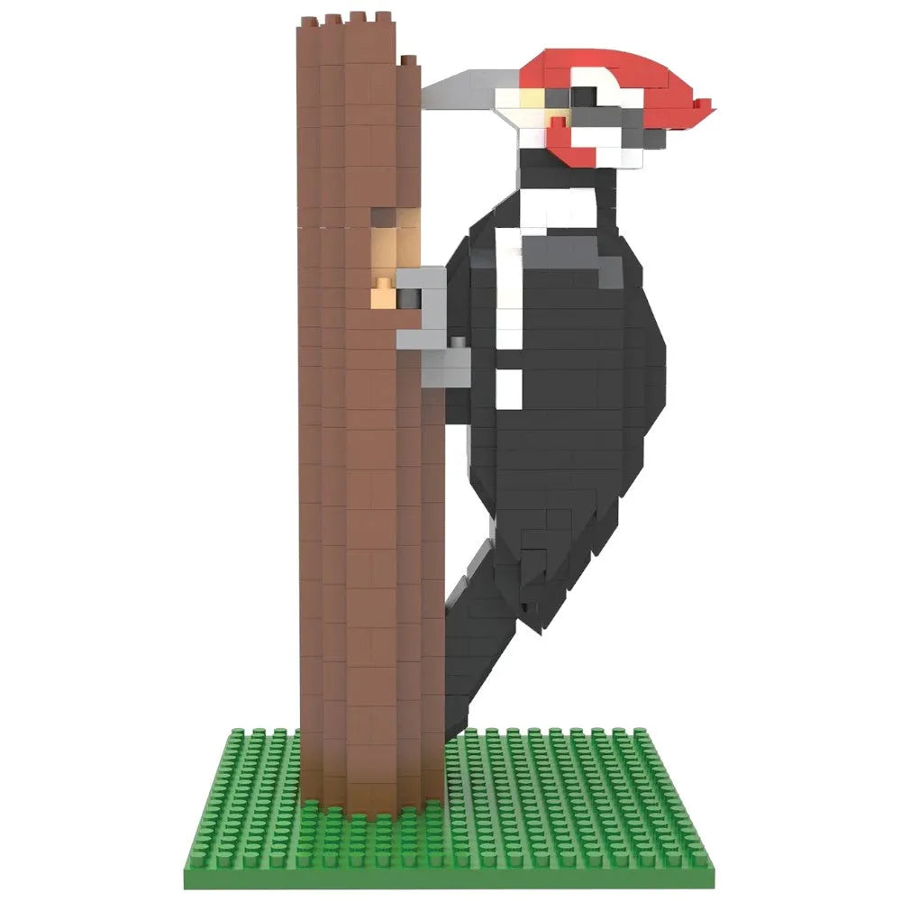 Toy figure of a woodpecker on a tree trunk with a green baseplate on a white background