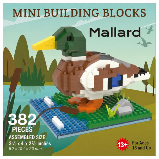 Box-style product graphic for a Mallard duck building block set. The image shows an assembled duck model made from mini building blocks on a blue base with green grass, a gray rock, and a brown reed, with text reading &