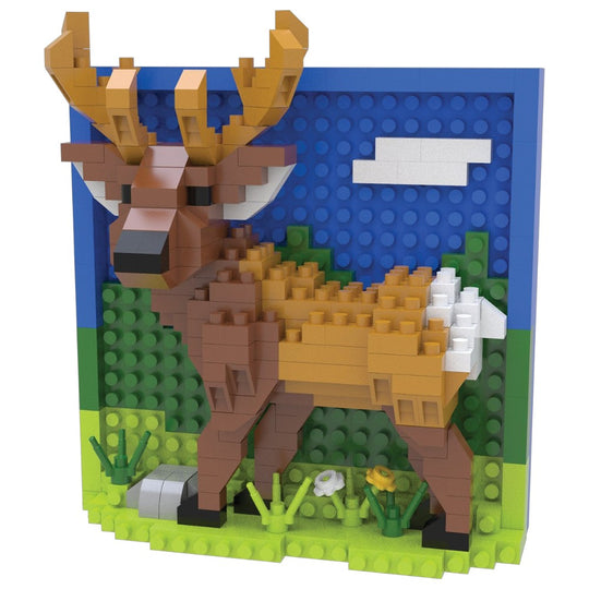 A block-built deer sculpture made from interlocking toy bricks, shown against a plain white background. The deer has tan and brown tones with white and black details, set in front of a blue sky and green hillside backdrop.