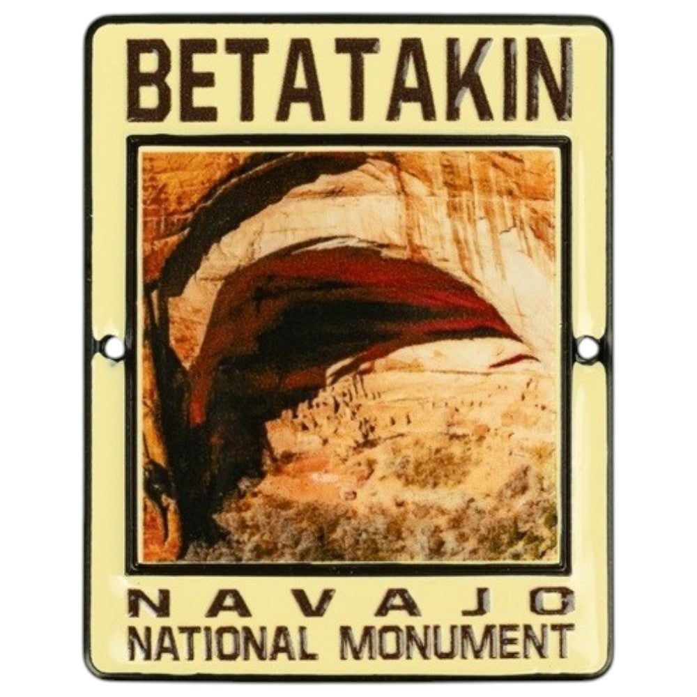 A rectangular metal medallion for Betatakin National Monument featuring a tan border, dark brown text reading &