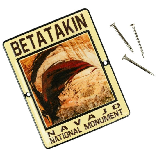 A rectangular metal medallion featuring the words &