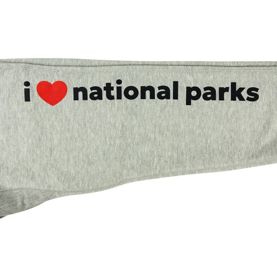 A close-up of a light heather gray garment, likely a sweatshirt sleeve, featuring the printed text &