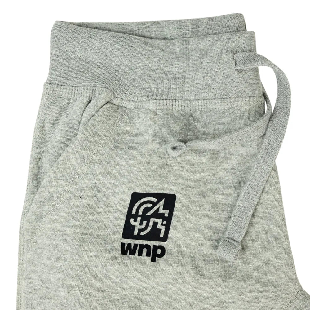 Close-up of light heather gray sweatpants with a black square logo patch on the front pocket and a matching gray drawstring, shown on a white background.