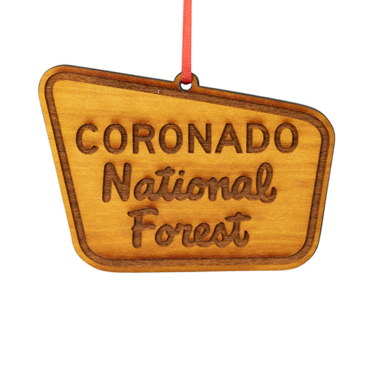 A wooden Coronado National Forest ornament shaped like a sign, with a red hanging string, shown on a plain white background.