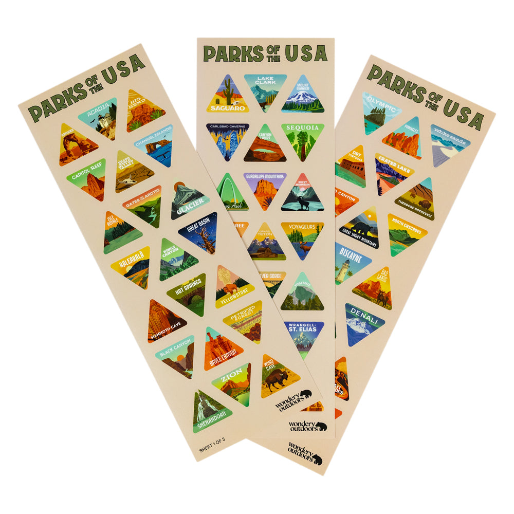 Three vertical sticker sheets titled "PARKS OF THE USA" arranged in a fan shape on a white background. Each sheet contains multiple colorful triangular stickers depicting different national parks with scenic illustrations and park names.