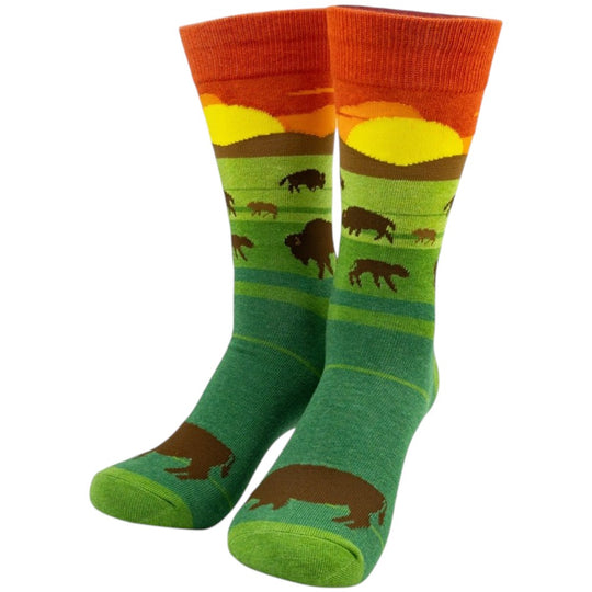 A pair of crew socks featuring a western landscape design with bison, shown on a plain white background.