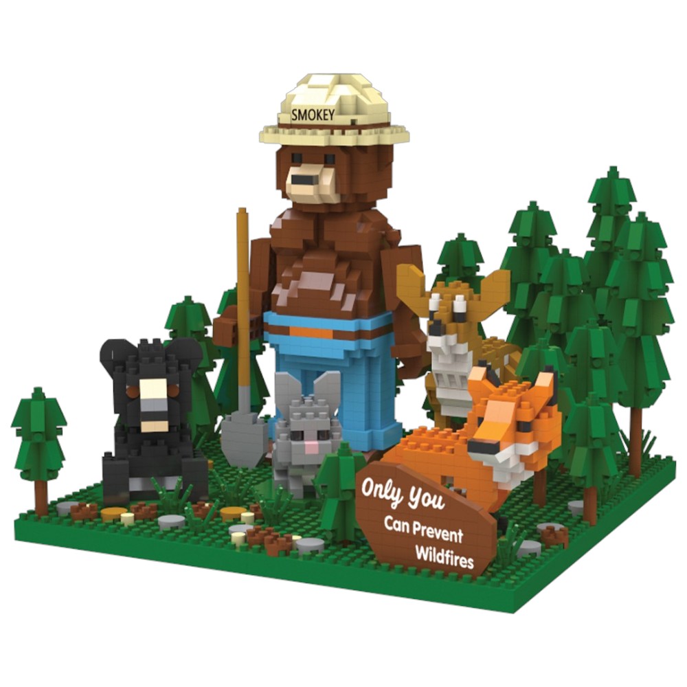 An image of the Smokey Bear and Friends building block set. It features Smokey Bear with his ranger flat hat and shovel, standing in a forest with a deer, bear, rabbit, fox, and his slogan "Only You Can Prevent Wildfires." 