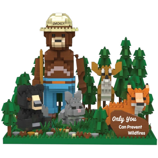 An front view of the completed of the Smokey Bear and Friends building block set. It features Smokey Bear with his ranger flat hat and shovel, standing in a forest with a deer, bear, rabbit, fox, and his slogan "Only You Can Prevent Wildfires." 