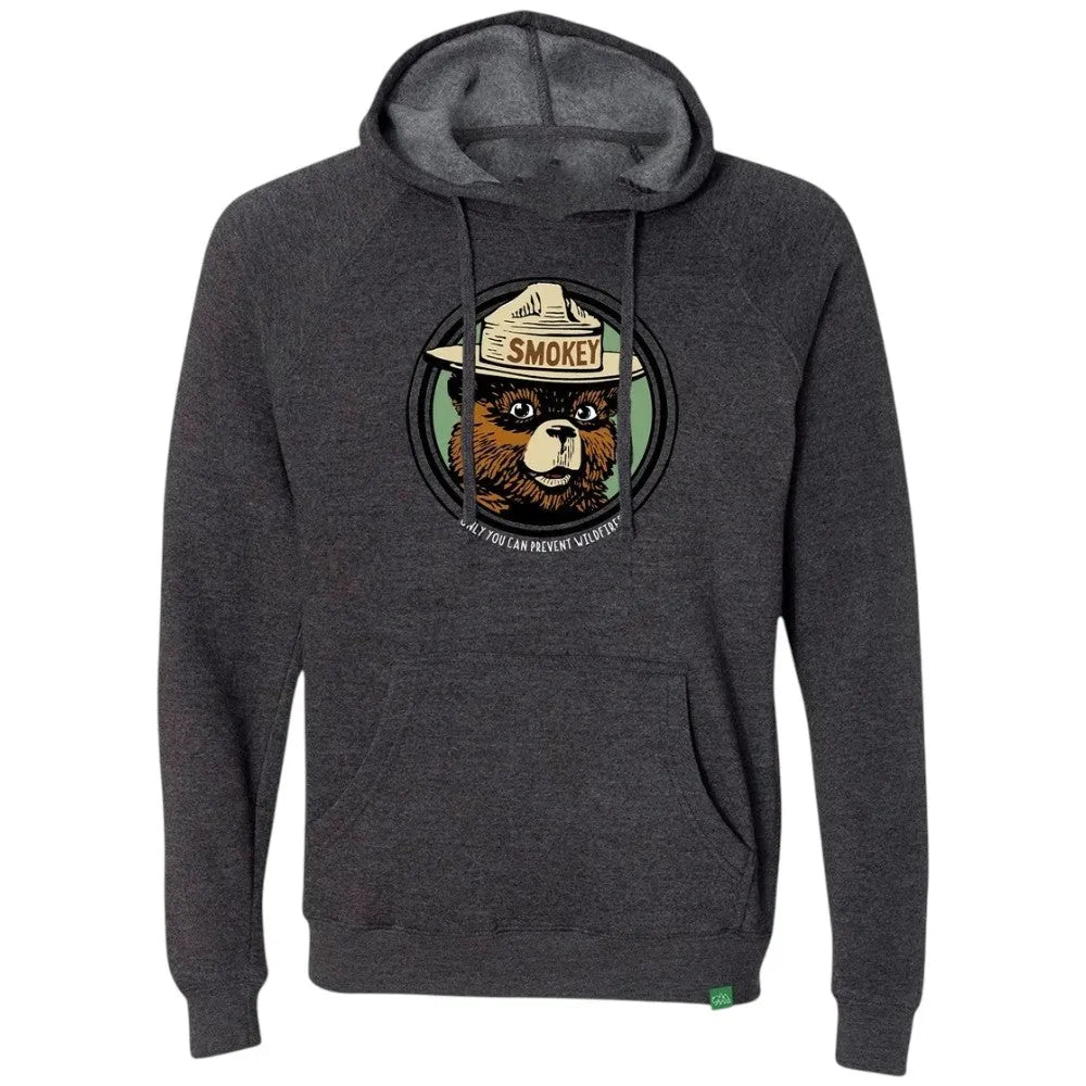 A dark heather gray pullover hoodie featuring a circular graphic of Smokey Bear wearing a Smokey hat on the chest, with the text "ONLY YOU CAN PREVENT WILDFIRES" below the illustration.