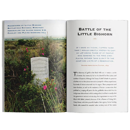 An open book showing a two-page spread with a landscape photograph of a grassy field and stone monument on the left page, and the title &