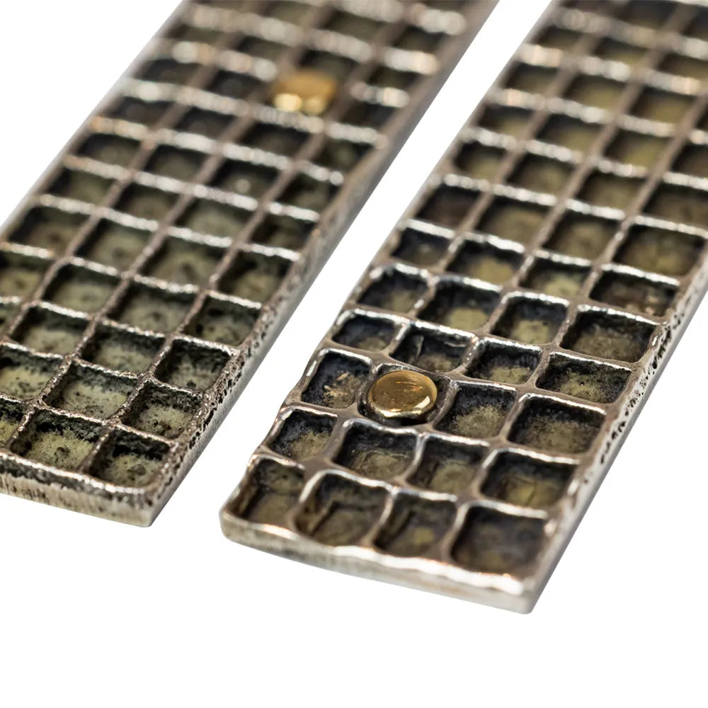 Pair of rectangular earrings with textured design on a white background