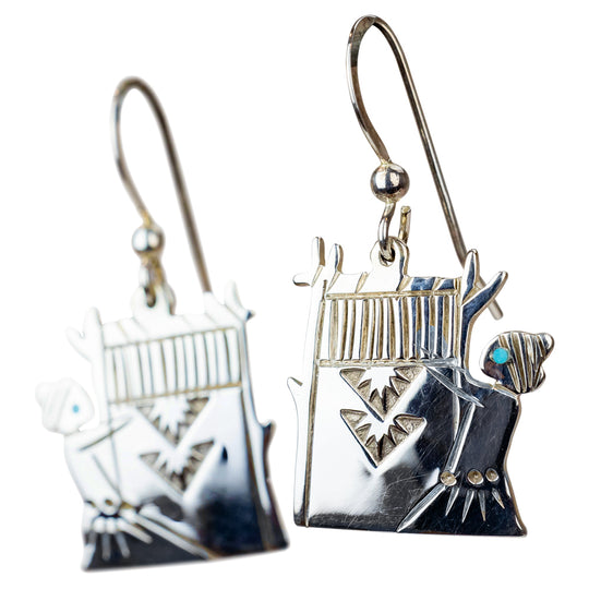 Silver earrings with intricate designs on a white background