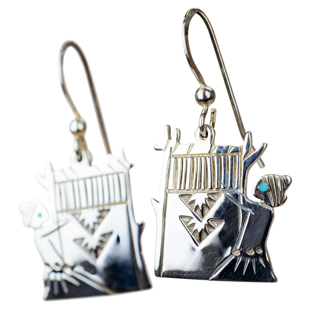 Silver earrings with intricate designs on a white background