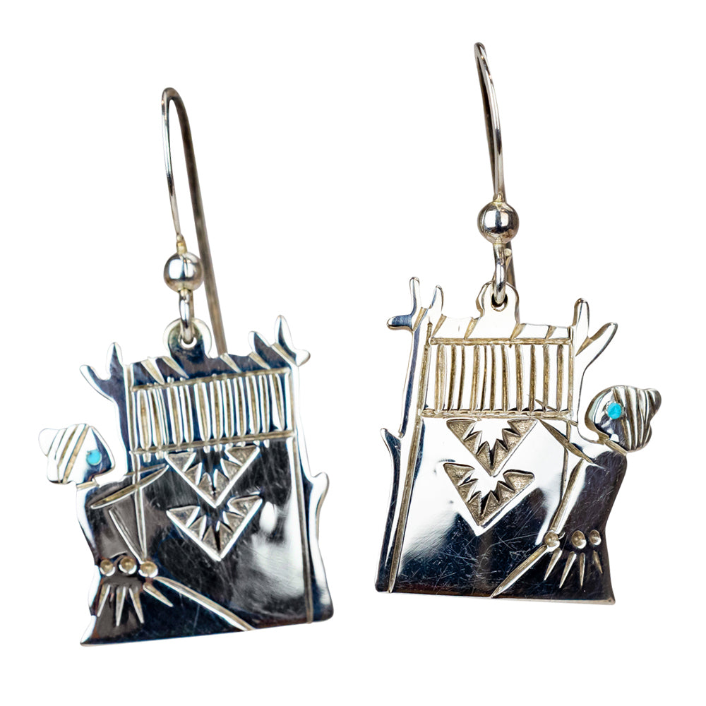 Silver earrings with intricate designs on a white background