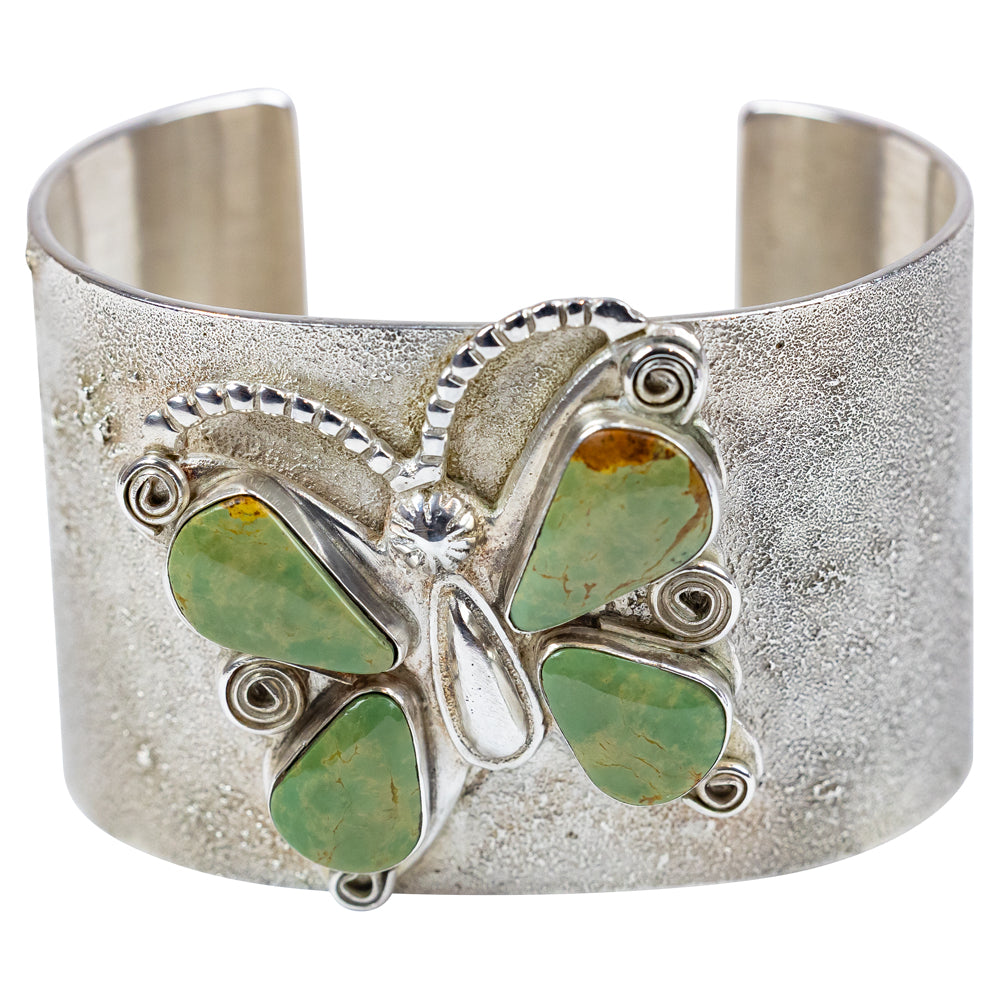 Silver cuff bracelet with green stone butterfly design on a white background