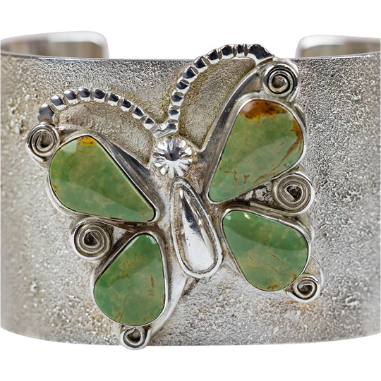 Silver bracelet with green stone accents  in a butterfly shape on a white background