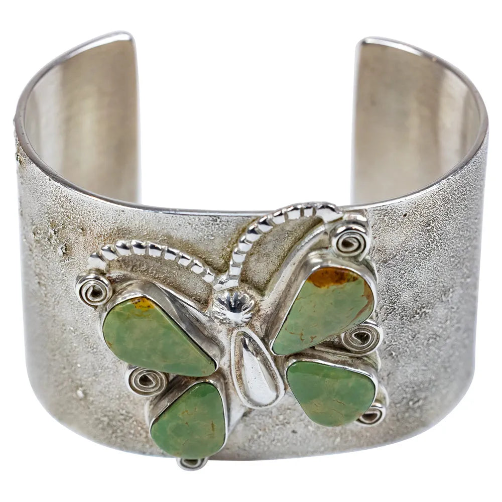 Silver cuff bracelet with green stone butterfly design on a white background