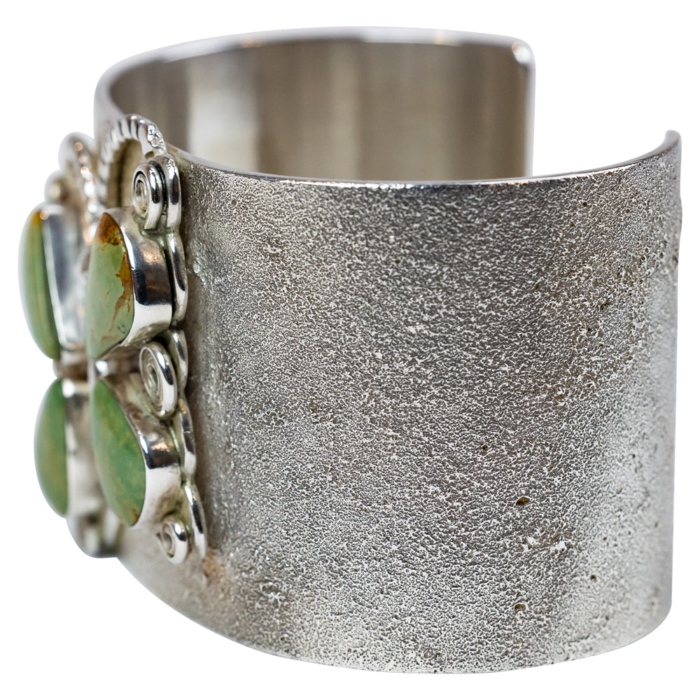 Silver cuff bracelet with green stone butterfly design on a white background