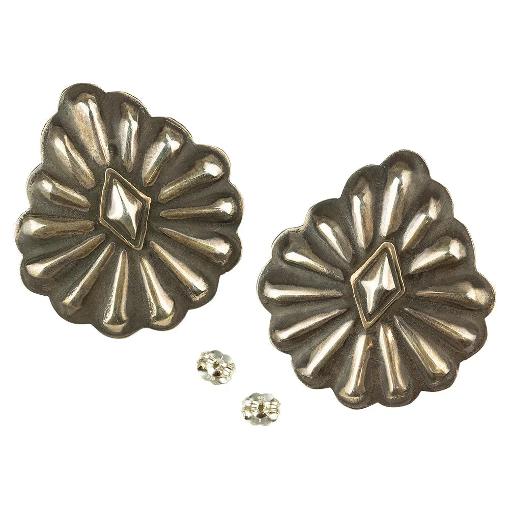 Pair of metallic concho-style earrings on a white background