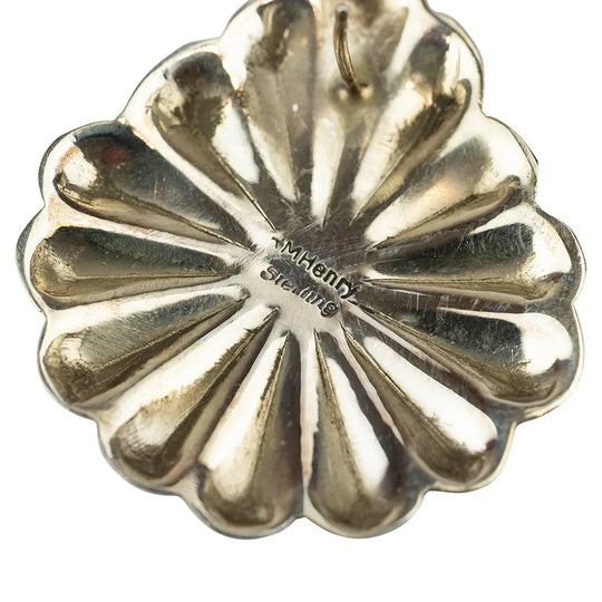 Close-up of a sterling silver earring with 'MHenryi' hallmark on a white background