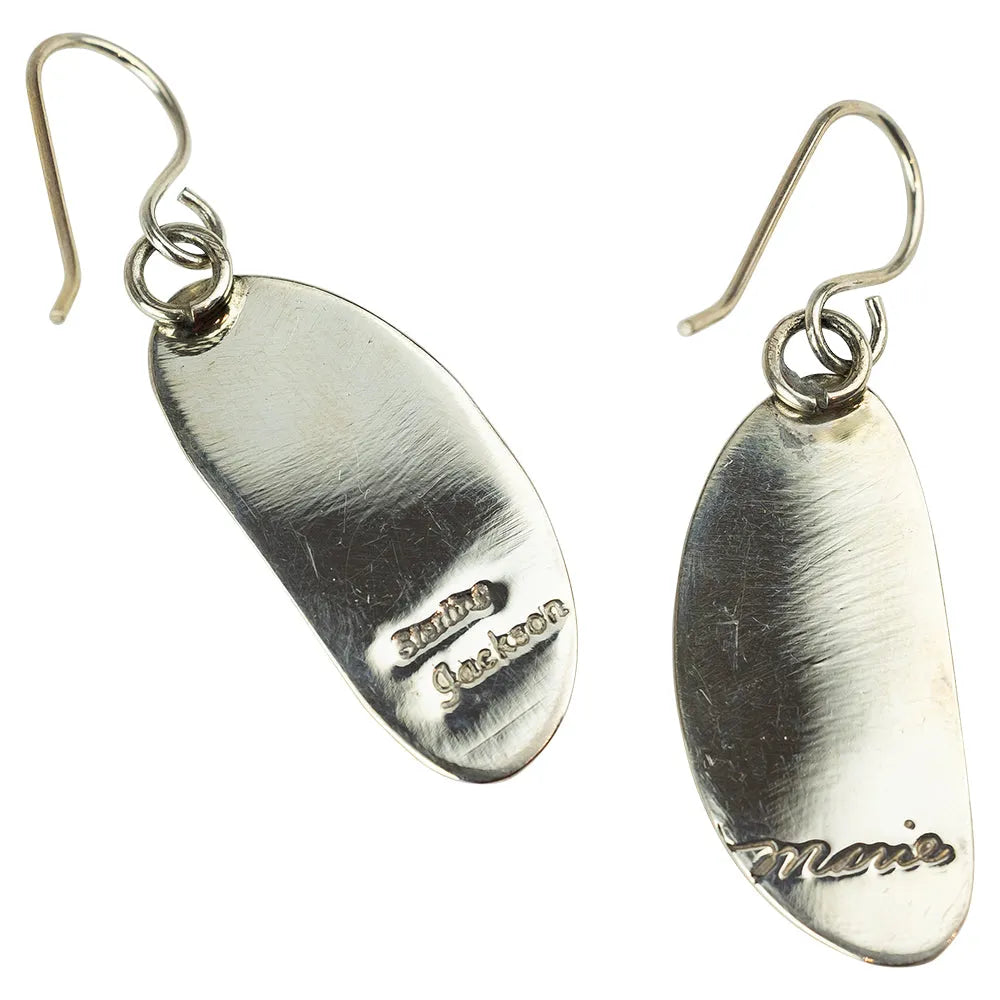 Pair of sterling silver earrings with engraved hallmarks on a white background