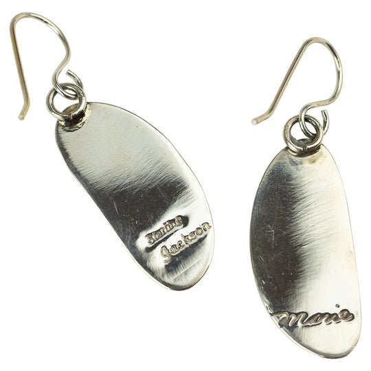 Pair of sterling silver earrings with engraved hallmarks on a white background