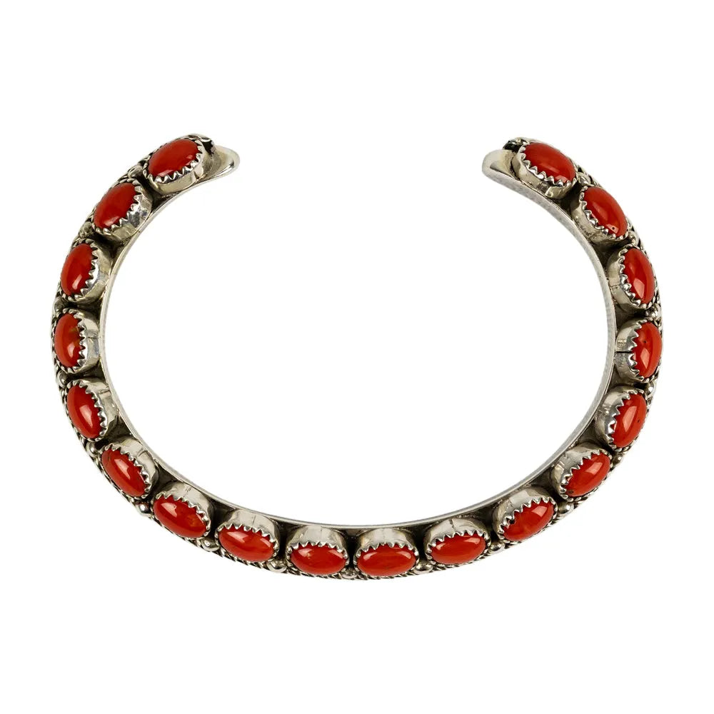 Silver bracelet with red stones on a white background