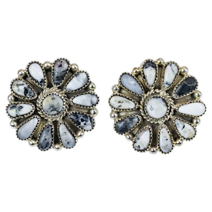 Pair of floral shaped earrings with gemstones on a white background