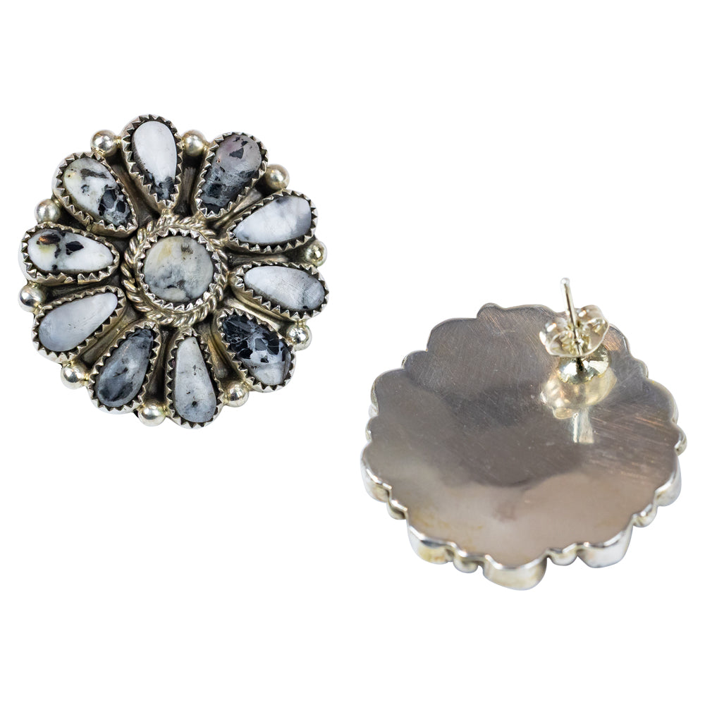 Pair of floral shaped earrings with gemstones on a white background