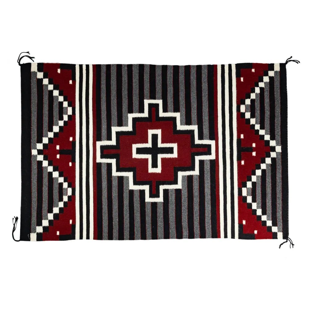 Handcrafted woven Navajo textile with geometric pattern on a white background