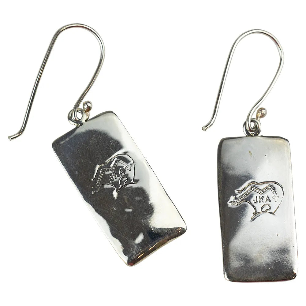 Pair of silver earrings with engraved hallmark designs on a white background