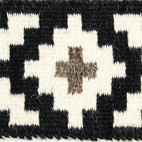 Close-up of a woven pattern with black and white diamond shapes and a central brown star.