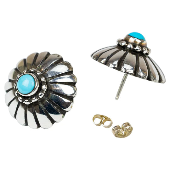 Pair of silver earrings with turquoise stones on a white background